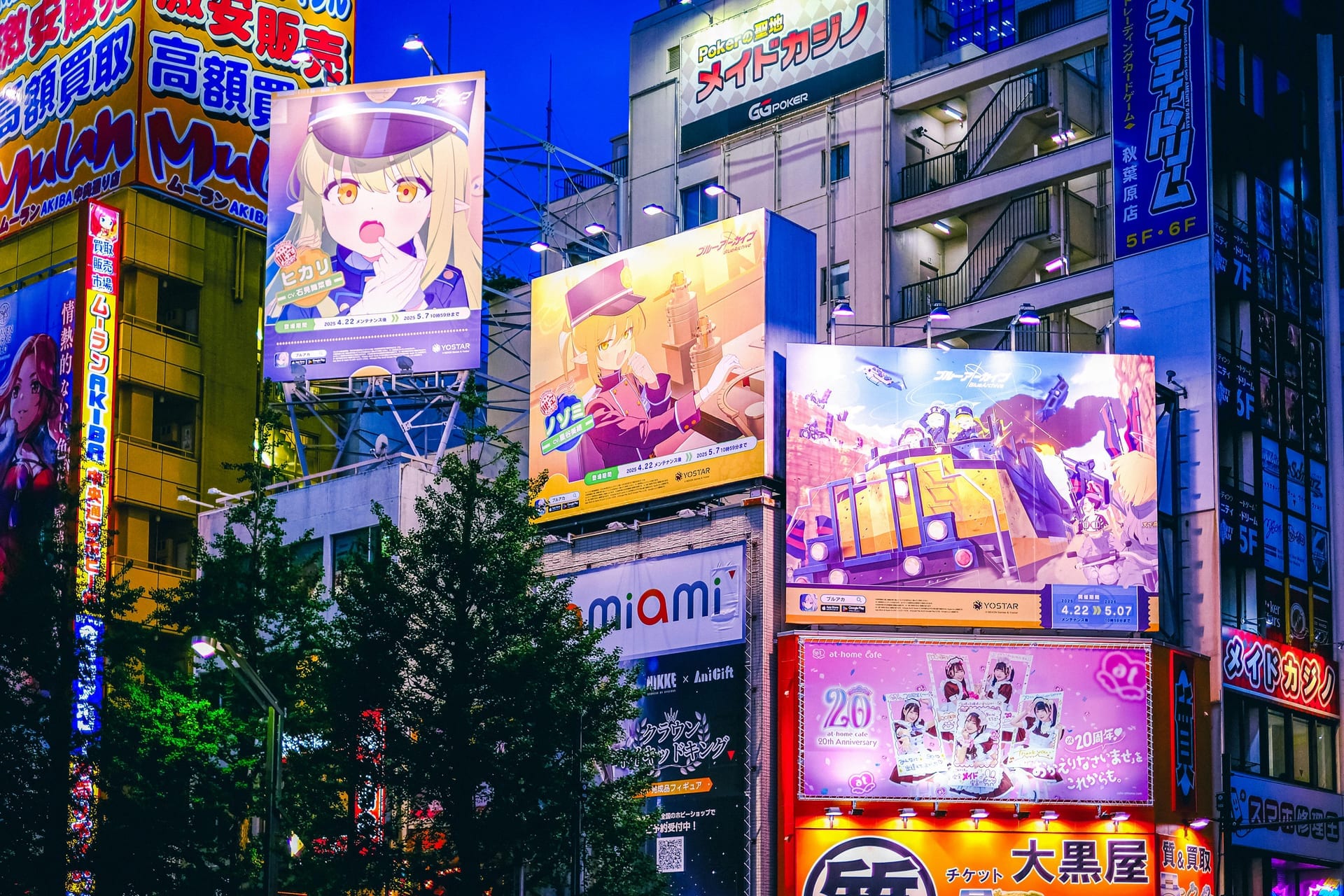 Akihabara main street with neon billboards, giant anime advertisements, and multi-story electronics and pop culture shops lining both sides